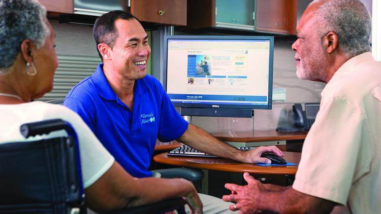 Florida Blue Center employee helping visitors at computer