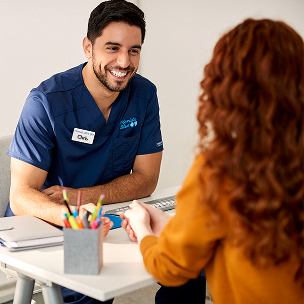 Male Florida Blue Center employee consulting with woman