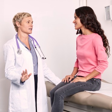 proveedor de atención médica con bata blanca aconsejando a un paciente