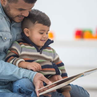 padre leyendo un libro a su hijo