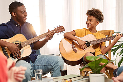 Padre e hijo tocando guitarras