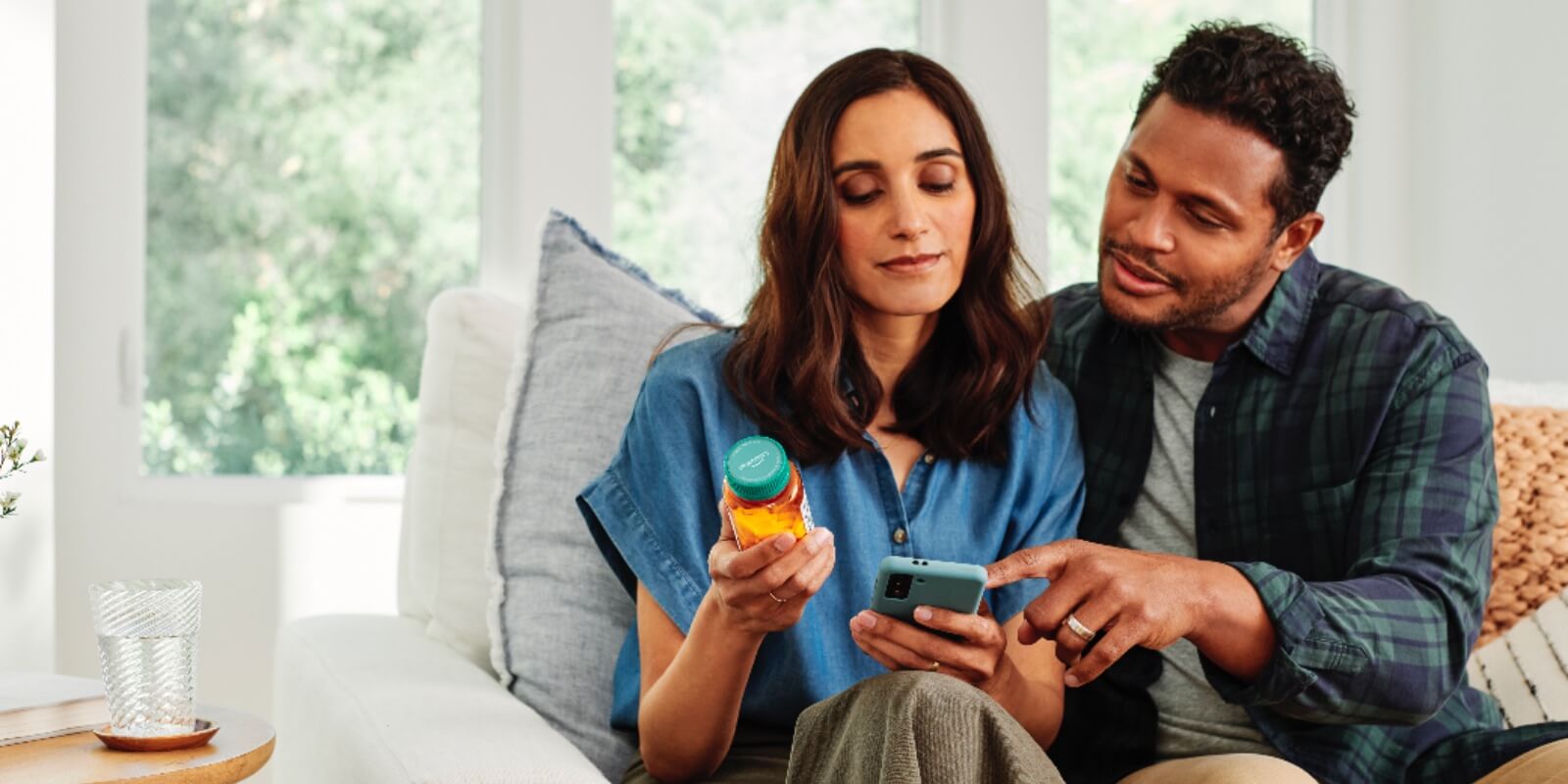 couple looking at prescription drug bottle and phone