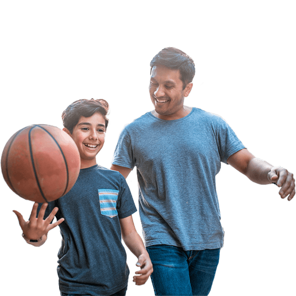 Boy spinning basketball while walking with father