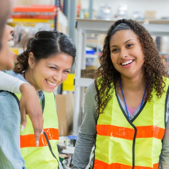Multiple employees in large warehouse laughing on break