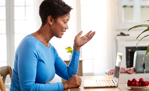 woman learning about health insurance plans on laptop
