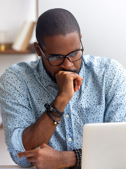 Worried man looking at laptop